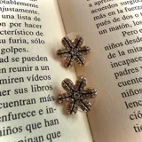 Aros en forma de flor con detalles de strass y acabado dorado.