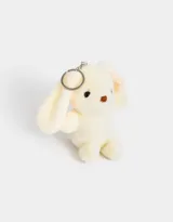 Llavero con dije de conejo de peluche color crema con orejas largas y detalles bordados en marrón. Incluye aro y mosquetón metálico plateado.
