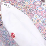 Bolso tote extra grande con estampado multicolor y asas de cuero sintético blanco.