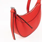 Cartera bandolera de cuero sintético color rojo con correa al hombro.