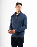 Buzo azul de punto con medio cierre, cuello alto y mangas largas.