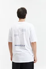 Remera blanca de manga corta con estampado de flores y texto en la espalda.