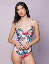 Malla enteriza estampada con motivos florales y hojas en tonos azules, rojos, amarillos y verdes. Escote en V cruzado y breteles regulables.