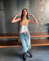 Top halter de cuero color beige en la parte superior y plateado en la parte inferior, con cuello alto y detalle de tachas.