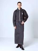 Falda larga Adidas color gris oscuro con finas rayas verticales blancas. Tiene bolsillos delanteros y logo de la marca bordado en el bolsillo trasero.