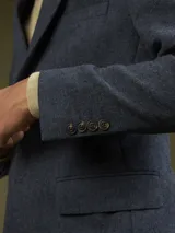 Blazer de vestir color verde oliva con textura tweed, solapa de muesca y cierre de dos botones.