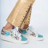 Zapatillas blancas con puntera y talón celeste brillante, laterales con estampado de piel de serpiente, estrella dorada en el lateral y cordones blancos.