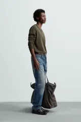 Jersey verde oscuro de punto fino, con cuello en V y mangas largas.