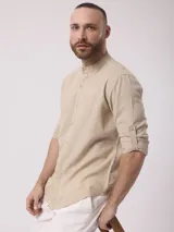 Camisa de manga larga color crudo, confeccionada en lino. Presenta cuello mao y cierre frontal con botones. Marca La Dolphina.