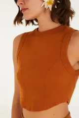 Top color beige, corte crop, con escote redondo y tirantes anchos.