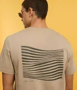 Remera color arena de algodón peruano, de corte recto, cuello redondo y manga corta. Presenta un pequeño estampado en el pecho.