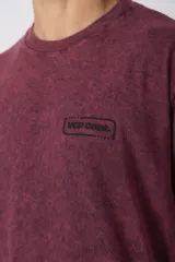 Remera gris oscuro con efecto gastado, de algodón peinado, con cuello redondo y estampado pequeño en el pecho.