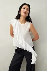 Top blanco de tencel sin mangas, de corte asimétrico, con volados en diagonal.