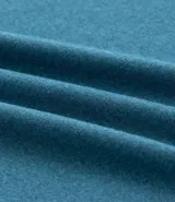 Remera deportiva de hombre color beige, manga corta, cuello redondo y corte ajustado. Presenta costuras raglán y una pequeña etiqueta en el dobladillo de la manga.