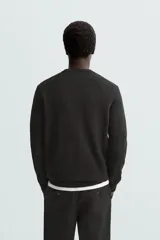 Jersey de hombre regular fit, color negro, tejido en hilatura de lana cashmere. Cuello redondo y manga larga con terminaciones en rib.