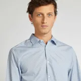 Camisa de vestir celeste con estampado de lunares pequeños, de corte clásico, manga larga y cuello italiano. Cierre frontal con botones.