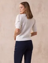 Cárdigan tejido color blanco, marca Tahari. Escote en V, manga corta abullonada con puño y abertura central con botones.
