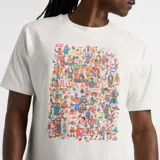 Remera color crema de corte clásico, con cuello redondo y estampado frontal con diseño de personajes y logo de New Balance.