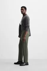 Pantalón color arena de corte recto, confeccionado en tejido elástico. Cuenta con cintura elástica ajustable con cordón, bolsillos laterales y bolsillos de vivo en la parte trasera.