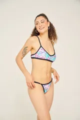 Conjunto de bikini con estampado animal print multicolor, compuesto por un corpiño triangular con tirantes finos y una bombacha tipo colaless con tiras finas ajustables en los laterales.