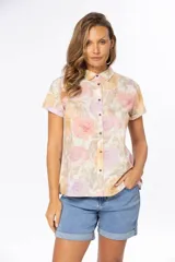 Camisa de manga corta con estampado floral en tonos pastel, cuello clásico y cierre frontal con botones.