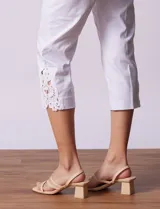 Pantalón capri blanco de gabardina elastizada con pretina ancha elastizada y ruedo con aplique de crochet.