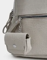 Mochila negra con efecto piel de cocodrilo, bolsillo frontal con cierre, charm de monedero colgante, correas regulables, manija superior, doble cierre superior y bolsillos laterales.