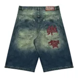 Bermuda baggy de jean con lavado verde, bordado en negro y rojo, cierre y botón personalizado, corte amplio y bolsillos grandes.