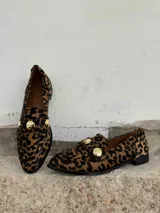 Mocasines de cuero con estampado animal print de cebra en blanco y negro, con apliques de strass plateados.