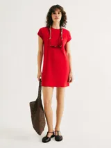 Vestido corto rojo con cuello redondo, mangas cortas y bolsillo en el pecho.