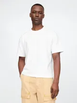 Remera corta blanca de algodón, con cuello redondo y mangas cortas.