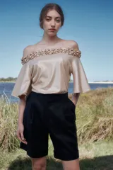 Bermuda negra de lino de talle alto con pliegues debajo de la cintura, piernas anchas con tablas y botamanga.