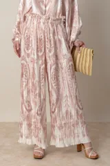 Pantalón palazzo de poliéster con estampado floral en tonos beige y rosa, cintura elastizada y corte plisado.