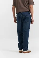 Pantalón de jean azul oscuro, corte recto, tiro medio, con bolsillos delanteros y traseros, y presillas para cinturón.