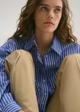 Camisa celeste con rayas verticales blancas, de corte crop y diseño oversize.