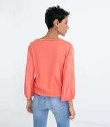 Blusa color salmón con escote redondo, mangas 3/4 amplias y ajuste frontal. Confeccionada en tejido laise.