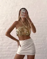 Top dorado con lentejuelas, estilo halter, con tiras regulables en cuello y espalda.