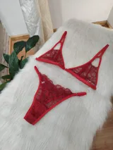 Conjunto de lencería rojo compuesto por un corpiño triangular de encaje con tirantes finos ajustables y una bombacha tipo colaless de encaje con bordes festoneados.