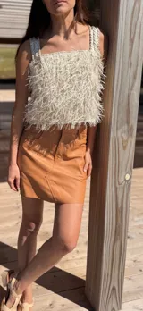 Top corto color nude dorado con textura de rafia y apliques artesanales de cuero a tono.