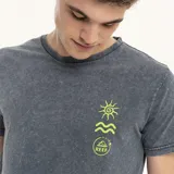 Remera gris con efecto gastado y estampado pequeño en el pecho con un sol, una ola y el logo de la marca.