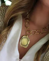 Collar dorado con cadena de eslabones grandes y dije irregular con forma de sello.