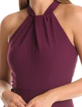 Enterito largo de crepe color rojo, con escote halter anudado y pierna ancha. Presenta bolsillos delanteros y abertura en la espalda con cierre invisible y botón.