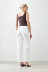Pantalón wide leg color crudo con pinzas delanteras y cierre con botón y cremallera.