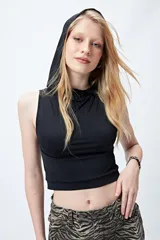 Top negro sin mangas con capucha, corte cropped y silueta ajustada al cuerpo.