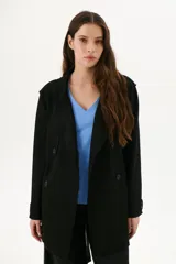 Trench simil gamuza color negro, con cuello de solapa muesca, cuatro botones delanteros, bolsillos laterales y cinturón a la altura de la cintura.