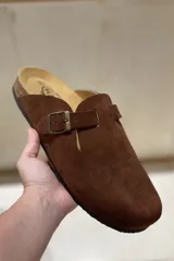 Zuecos grises marca Plakton, confeccionados en cuero vacuno, con hebilla lateral ajustable, plantilla anatómica con memory cushion y suela de goma y corcho.