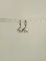 Par de aros colgantes de acero quirúrgico hipoalergénico con dije de elefante plateado.