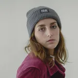 Gorro de lana blanco con etiqueta negra con el logo de la marca Pulau.