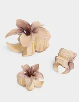 Set de tres broches para el pelo con forma de flor hawaiana, color blanco crudo con centro marrón.
