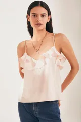 Top lencero color rosa pálido con breteles finos y volados en el escote.